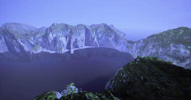 Stunning cliffs overlooking a serene dark lake at dusk in an isolated location video