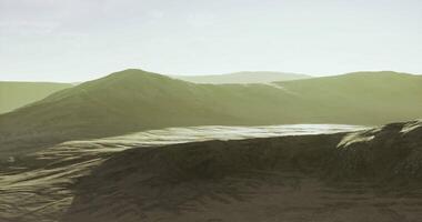 Expansive landscape with rolling hills under soft sunlight in tranquil setting video