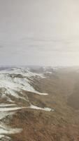 large snow patch left over on the volcanic rock field of a mountain in summer video