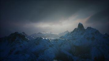 Majestic snow covered mountains under a dramatic sky at twilight video