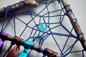 Elements of a dream catcher, beads, ribbons, wood, weaving from threads. An amulet for a restful sleep. Legends and myths. photo
