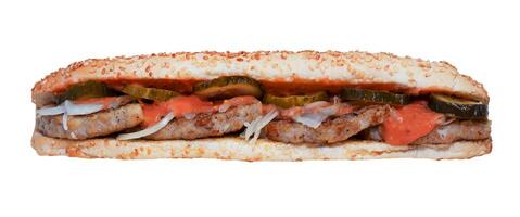 Long sandwich isolated on white background. Quick lunch - sesame bun. A simple sandwich with cutlet, chicken, lightly salted cucumber, onion and sauce on bread. Gas station menu photo