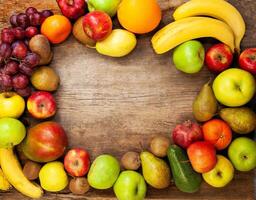 Frame from multi-colored different fruits on a wooden background. Harvest fruits top view. Bananas, apples and pears. Lemon, mango, avocado and grapes. photo