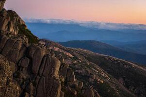 Granite mountain peak with sun setting in the background photo