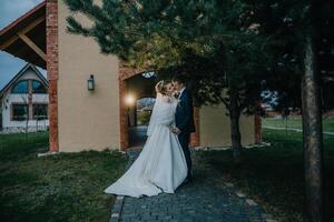 bride and groom are standing in front of a building photo