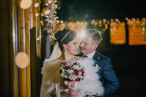 bride and groom are standing together in front of a window. photo
