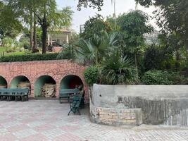 a small park with benches and a fountain in Lahore on 10-10-2024 photo