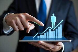 Hand points to tablet with holographic figure on graph, symbolizing growth photo