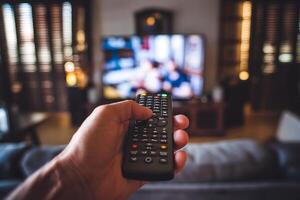 Remote points at TV in cozy room, creating a relaxed atmosphere photo