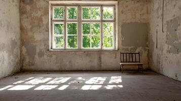 Sunlit abandoned room with rustic charm and large window casting shadows on the textured floor photo
