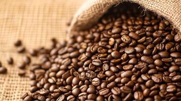 Close View of Dark Roasted Coffee Beans Overflowing from Burlap Sack on Rustic Background photo