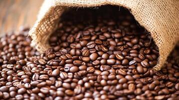 Rustic burlap bag spilling fresh aromatic roasted coffee beans on wooden table photo