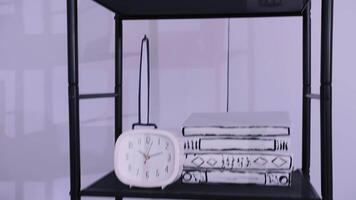 Sketch-style shelf with books and clock in a minimalist interior video