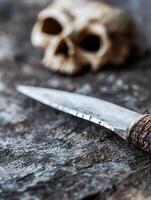 Sharp Steel Knife with Bone Handle on Rustic Stone Surface and Human Skull in Background photo