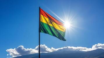 Vivid Bolivian Flag Flying Against a Blue Sky with Sunlight and Mountain Scenery photo