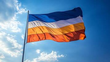Multicolored Striped Flag Waving Against Clear Blue Sky Symbolizing Unity and Diversity photo