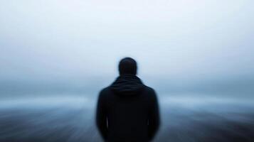 Solitary Figure in Blur Gazing at Ocean Creating Sense of Solitude and Reflection photo