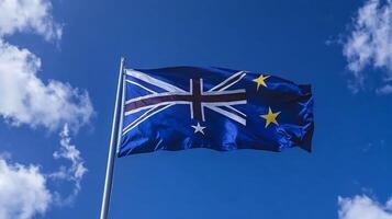 Vibrant national flag waving on flagpole with clear blue sky and scattered clouds photo