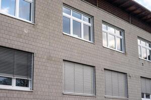 Modern building facade featuring windows and venetian blinds photo