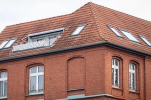 Red brick building with balcony and skylights showing urban living photo