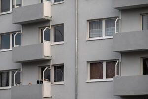 Grey apartment building facade showing balconies and windows photo