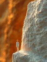 A miniature person standing on a cliff edge photo