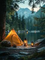 A tent is set up near a lake with a lantern photo