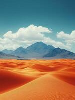 A vast desert landscape with rolling orange sand dunes and distant mountains under a blue sky. photo