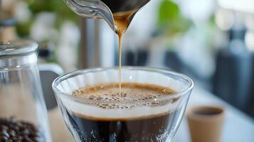 Close-up of freshly brewed coffee pouring from pot into transparent glass carafe photo