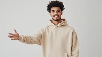 Friendly young man extending hand for a handshake in casual hoodie attire photo