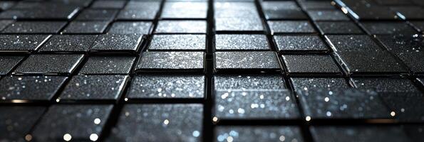 Close-up view of shiny black tiles with water droplets creating a reflective surface photo