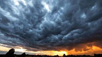 Dramatic Stormy Sky at Sunset with Dark Clouds and Vibrant Orange Horizon photo