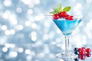 Refreshing blue cocktail garnished with red berries and mint on reflective surface with blurred background photo