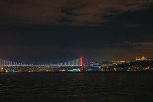 Bosphorus Bridge Illuminated at Night with Istanbul Skyline photo