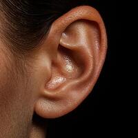 Close up of a womans ear, showing intricate details and skin texture. photo