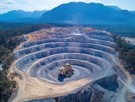 Excavators working in open pit mine with mountain range background photo