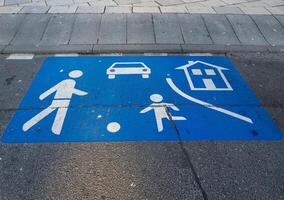 Pedestrian crossing with vehicle and home symbols in urban area promoting safety and awareness for families photo