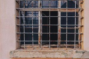 Rusty barred window on an old building showcasing wear and decay in an urban environment photo