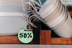 Discounts on disposable cups displayed in a wooden crate at a market stand during daytime photo