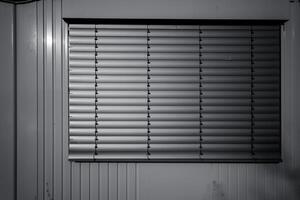 Light filtering through closed blinds in a quiet room during the early morning hours photo