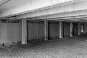 Concrete parking garage with closed doors and patterned flooring in urban setting during daylight hours photo
