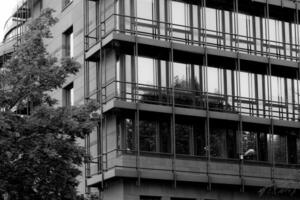 Modern architecture reflects surrounding trees in a contemporary urban setting during the day photo