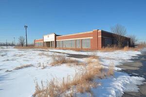 An abandoned building sits in the middle of a snowy field photo