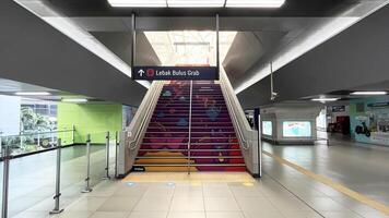 a stairway with colorful designs and a sign. A view inside of Blok M MRT Station in Jakarta photo