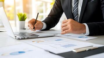 A manager discussing the onboarding process with a new employee, sitting at a desk with office documents and a laptop photo