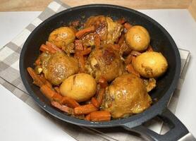 Delicious Ayam Kecap or Indonesian style sweet soy sauce chicken with carrots and hard-boiled eggs, served in a black pan. Perfect for recipes, articles, catalogs or any commercial purpose. photo