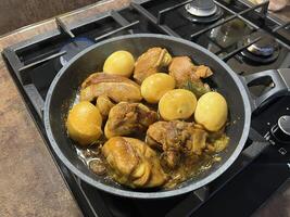 Close up of Sweet soy sauce chicken or Ayam Kecap with hard-boiled eggs, served in a black pan on the stove. Perfect for recipes, articles, catalogs or any commercial purpose. photo
