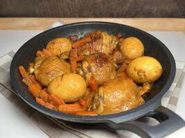 Sweet soy sauce chicken or Ayam Kecap with carrots and hard-boiled eggs, served in a black pan. Perfect for recipes, articles, catalogs or any commercial purpose. With copy space. photo