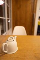 sitting in cafe with wooden cozy comfy environment background with a cup of tea pot and empty chair sit photo