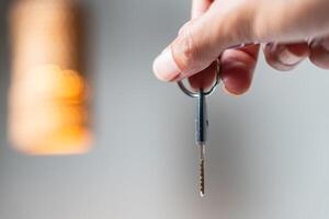 Hand Holding a Key with Warm Background Light photo
